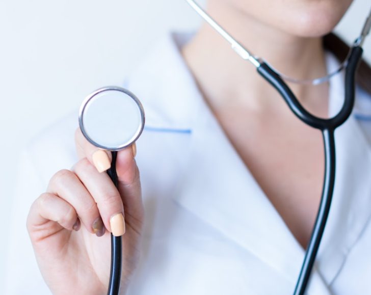 a woman in a white shirt holding a stethoscope {{brizy_dc_image_alt imageSrc=